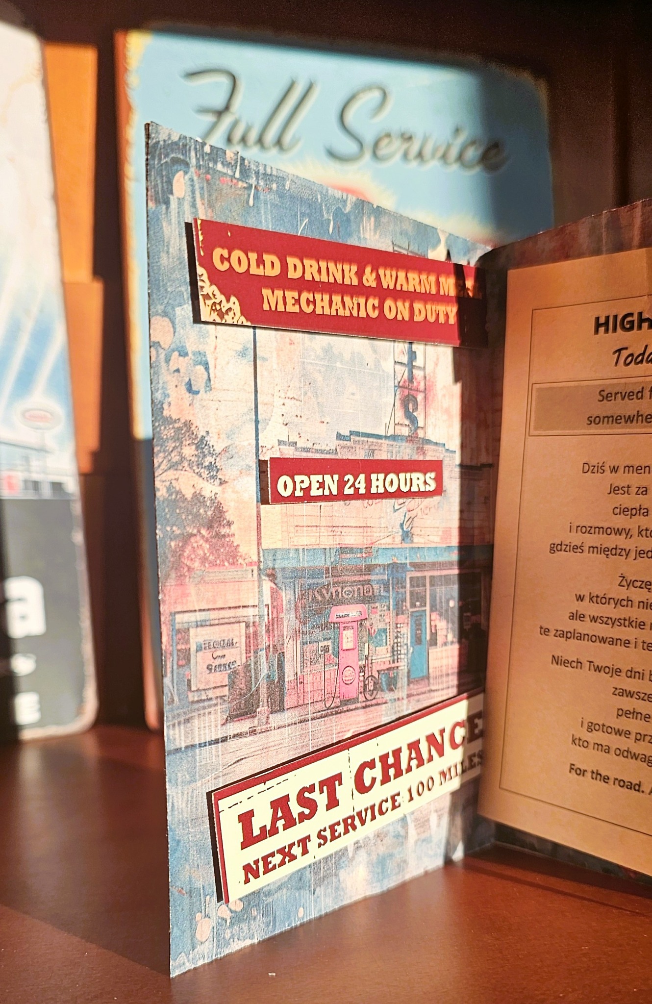 Detal wnętrza kartki ze stacją paliw i napisem Open 24 hours